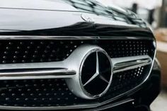 the front end of a black mercedes car with chrome grilles and grill vents on it