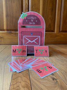 a pink mailbox with matching cards and magnets on the floor next to it