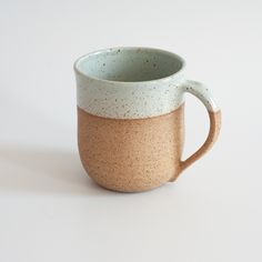 a brown and blue mug sitting on top of a white table