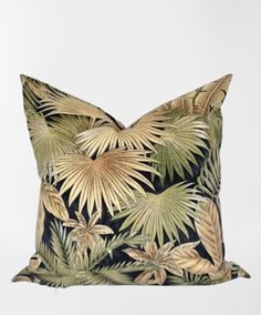 a black and gold pillow with palm leaves on it