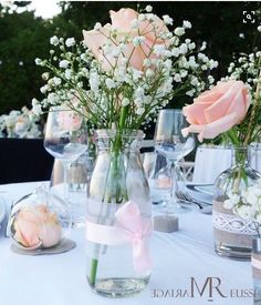 there are many vases with flowers in them sitting on the table at this wedding reception