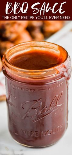 a jar filled with bbq sauce sitting on top of a table