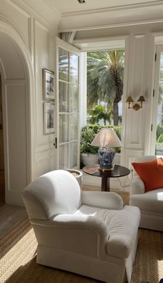 a living room filled with white furniture and lots of windows