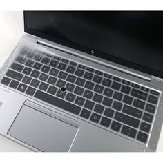 an open laptop computer sitting on top of a white table next to a black keyboard