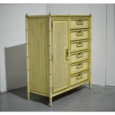 a yellow cabinet with drawers and bamboo handles