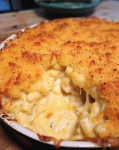 macaroni and cheese casserole in a white dish on a wooden table