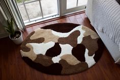 a brown and white rug sitting on top of a wooden floor next to a window