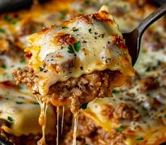 a fork full of lasagna casserole being lifted from a skillet