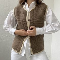 a woman wearing a brown vest and white shirt