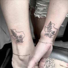 two people holding hands with tattoos on their arms and the map of minnesota behind them