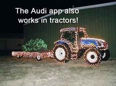 a tractor decorated with christmas lights in front of a barn