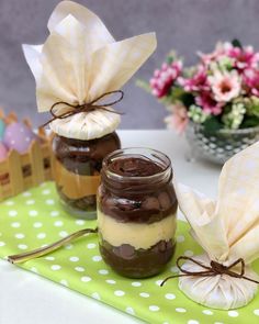 two jars filled with food sitting on top of a green table covered in white polka dots