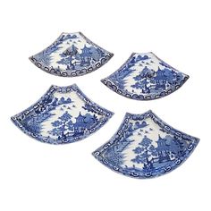 four blue and white plates with designs on the sides, one is shaped like a pagoda