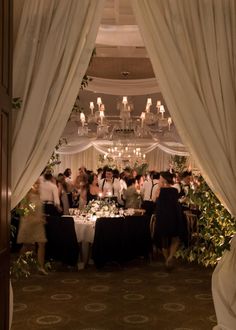 a group of people standing in front of a table covered with white draping