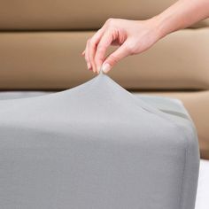 a person is placing something on top of a bed sheet that has been folded over