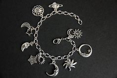 A collection of silver plated night sky themed charms have been dispersed around a shimmering silver plated bracelet chain in this handmade charm bracelet. This celestial charm bracelet is then completed with a lobster clasp and a 1/2 inch of chain at the end for adjustable sizing. Charms in this bracelet include a four sun charms, five moon charms, two star charms, and a Saturn charm. ● Sizing ● To determine your bracelet size, do a snug measurement of your wrist's circumference, then add 1/2 a Celestial Silver Bracelet With Star Charm, Silver Celestial Bracelet With Star Charm, Sterling Silver Bracelets With Moon Charm, Celestial Sterling Silver Bracelets, Silver Celestial Bracelets For Gift, Sterling Silver Celestial Bracelet With Moon Charm, Sterling Silver Moon Charm Bracelet, Silver Moon-shaped Sterling Silver Bracelet, Adjustable Silver Celestial Charm Bracelet