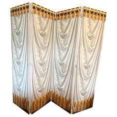 a white room divider with gold trimmings on the sides and bottom panels