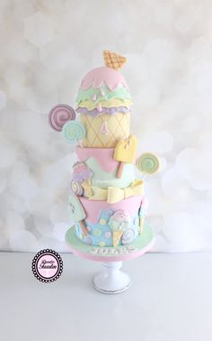 a three tiered cake with an ice cream cone and candy toppings on top