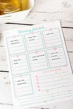 a printable cleaning schedule on a table next to a cup of tea