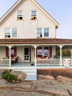 a white house with red shutters on the front porch