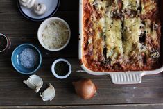 a casserole dish with mushrooms, cheese and other ingredients on a wooden table