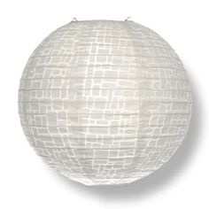 a round white paper lantern hanging from a string on an isolated wall with no background