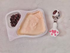 a plastic container with food in it next to a spoon and scooper on the table