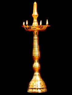 a golden candle holder with five lit candles on the top and bottom, against a black background