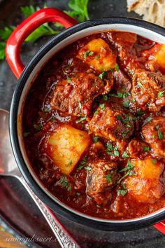 a bowl filled with stew and bread on top of a table