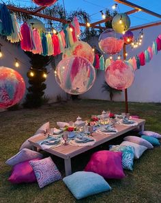 a table set up for a party with balloons and streamers