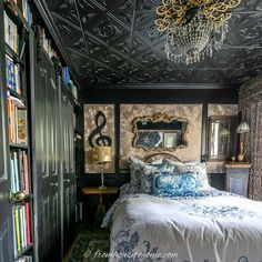 a bed sitting in a bedroom next to a book shelf filled with lots of books