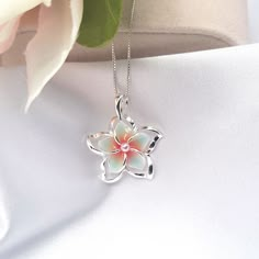 This Sterling Silver Rainbow Plumeria Necklace is the perfect accessory for anyone looking to add a touch of Hawaiian-inspired style to their look. Crafted with 925 sterling silver, this beautiful necklace features a colorful plumeria flower surrounded by intricate detail. The ideal beach gift, this plumeria pendant is sure to make a lasting impression. - Comes ready to wear on a 925 sterling silver chain of your choice length. Comes standard on a box style chain.  - solid sterling silver plumeria flower pendant accented with a faux pearl   Approx 20 mm in size Custom made to order so yours may look slightly different from the above pictures. Due to different monitors and settings colors may appear slightly different. Summer Jewlery, Abalone Jewelry, Wave Jewelry, Hawaiian Jewelry, Jewelry Flower, Jewelry Lookbook, Cz Jewelry, Fancy Jewelry, Flower Jewelry