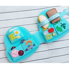 two children's purses with patches and buttons on them sitting on a wooden surface