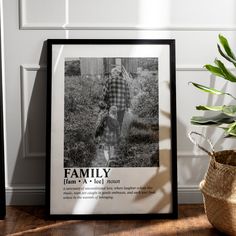 a black and white photo of a family in front of a plant on the floor