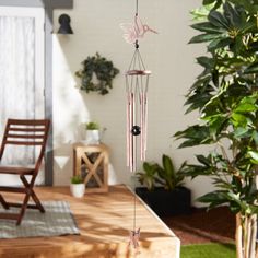 a wind chime hanging from the side of a wooden table next to a potted plant