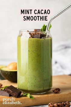 a green smoothie in a glass with chocolate chunks and mint leaves on the side