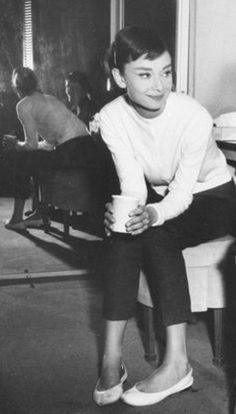 a black and white photo of a boy holding a coffee cup