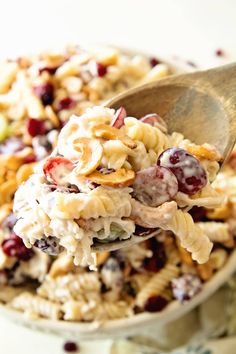 a spoon full of pasta salad with grapes and nuts