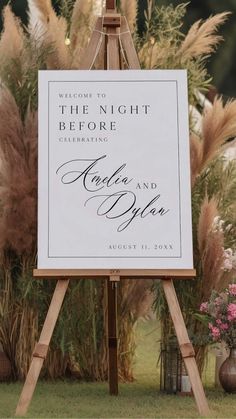 an easel with a sign on it in front of some flowers and grass that reads, the night before celebrating