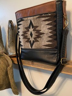 Handcrafted Southwest Cross-Body Tote Handbag.  Wool gray and brown tone design is surrounded by black and brown leather on both front and back.  Front of bag offers a zipper pocket.  Back of bag features a slip pocket with black leather pipping.   Interior is completely padded on all sides with waterproof canvas in striking gold with black leather pipping and includes a padded zipper pocket and two padded slip pockets, making this small bag a five pocket wonder.   With the addition of six metal Brown Leather Trim Shoulder Bag For On-the-go, Black Leather Lined Crossbody Bag, Black Leather Lining Crossbody Bag, Black Leather-lined Crossbody Bag, Black Rectangular Shoulder Bag With Leather Trim, Brown Rectangular Bag With Leather Trim, Black Leather Shoulder Bag With Leather Trim, Brown Leather Shoulder Bag With Leather Trim, Black Leather Crossbody Satchel