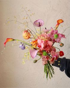 a woman holding a bouquet of flowers in her hand