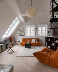 a living room filled with furniture and a skylight in the corner on top of it