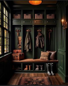 an entryway with green painted walls and wooden flooring, two coats hanging on the coat rack