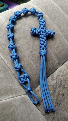 a blue cross is attached to the back of a gray couch with a black cord