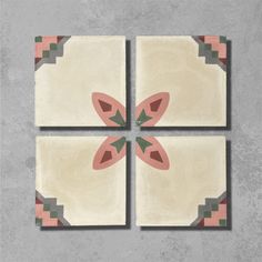 four square tiles with pink and green designs on the top one has an orange flower