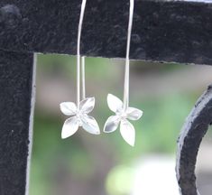 Long silver flower earrings in lotus shape made of 925 sterling silver The flower has four petals and four stamens, hand fabricated to  These earrings would make a fabulous gift for any artistic woman in your life whether it be to celebrate a birthday or honor a special occasion, or better gift yourself. Ear wires are flexible and allow closure to your convenience. ⫷ Measures Flower size is 0.6 X 0.6" (1.5X1.5 cm) Drop is 1.5 inch (3.8 cm) ♡ ♡ ♡ ♡ ♡ ♡ ♡ ♡ ♡ ♡ ♡ ♡ ♡ ♡ ♡ ♡ ♡ ♡ ♡ ♡ ♡ ♡ ♡ ♡ ♡ ♡ ♡ ♡♡ ♡ ♡ ♡ ♡ ♡ ♡ ♡ ♡ ♡ ♡ ♡ ♡ ♡ ♡ ♡ ♡ ♡ ♡ ♡ ♡ ♡ ♡ ⫷ Each piece of jewelry will come packaged in a beautiful black box, tied with a ribbon. then placed in a chiffon drawstring (organza) pouch, scattered with scented dried flowers. Great for gift-giving! Then shipped in a padded envelope. Want to send this Christmas Ale, Red Coral Earrings, Lotus Earrings, Silver Flower Earrings, Daisy Earrings, Long Dangle Earrings, Earrings Long, Wire Earrings, Floral Earrings