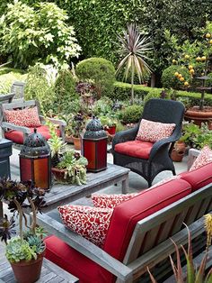 an outdoor seating area with red cushions and potted plants