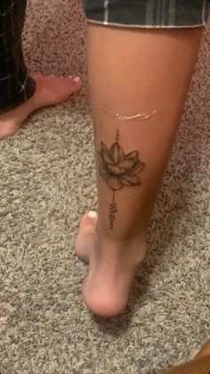 a woman's foot with a tattoo on it and a flower in the middle