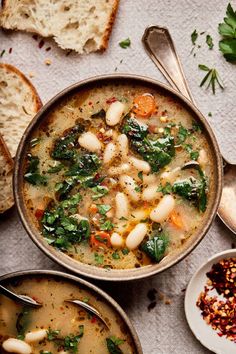 two bowls filled with soup next to slices of bread