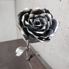 a metal rose sitting on top of a wooden table